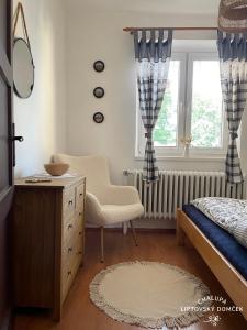 sypialnia z łóżkiem, komodą i oknem w obiekcie Chalupa Liptovský domček w Liptowskim Mikulaszu