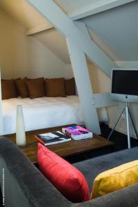 a living room with a couch and a bed and a table at Pol Hotel in Le Touquet-Paris-Plage