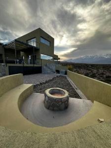 a building with a fire pit in front of it at Villamagna, casa en Potrerillos in Potrerillos