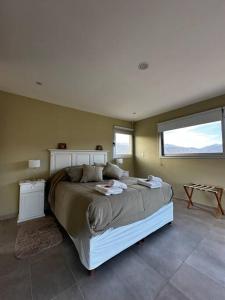 ein Schlafzimmer mit einem großen Bett und einem Fenster in der Unterkunft Villamagna, casa en Potrerillos in Potrerillos