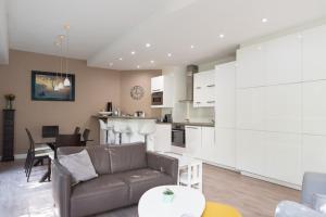 a living room with a couch and a kitchen at Spacious and quiet apartment with shared garden in Issy-les-Moulineaux