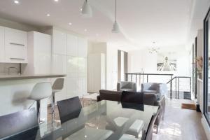 a kitchen and living room with a glass table at Spacious and quiet apartment with shared garden in Issy-les-Moulineaux