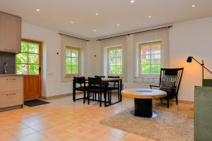 a kitchen and dining room with a table and chairs at Apartamentai Gėlių Vila in Nida