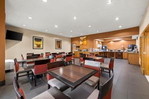 una sala da pranzo con tavoli e sedie e una cucina di Comfort Suites Kansas City-Liberty a Liberty