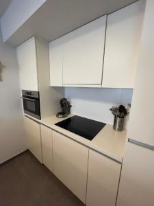 a kitchen with white cabinets and a sink at Vakantieappartement - Gratis garage - Topligging in Ostend