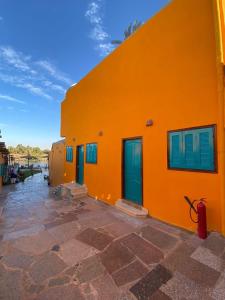 an orange building with blue doors and windows at Fenti Nubian Resort in Aswan