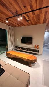 - un grand lit en bois dans un salon avec une télévision dans l'établissement Vila Piá, à Piaçabuçu