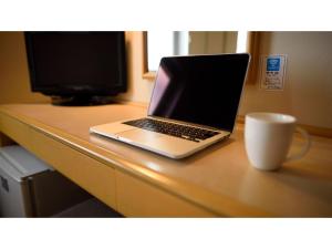 un ordenador portátil sobre un escritorio con una taza en Green Hotel Kitakami - Vacation STAY 09805v, en Kitakami
