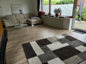 a living room with a couch and a rug at Ferienhaus Ahrensmoor - KEINE MONTEURE in Ahlerstedt +28 photos