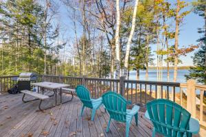3 sillas y una mesa en una terraza con parrilla en Cozy Chemo Pond Cabin with Dock and Waterfront Views, 