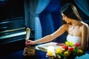een vrouw aan een tafel naast een piano bij Basztogród in Sanok