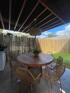 una mesa de patio con sillas y una maceta. en Vila Piá, en Piaçabuçu