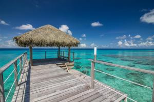 a pier with a straw hut on the water at Maitai Rangiroa in Avatoru