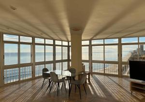 uma sala de jantar com mesa e cadeiras num quarto com janelas em Apartamento Edificio Rey I em Valência
