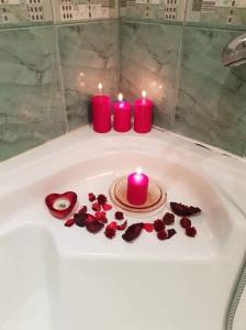 a group of candles and roses in a bath tub at Guest House Karov - 2 Stars in Chepelare