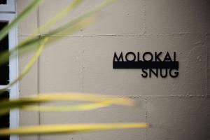 a brick wall with a moxican snug sign on it at Molokai Snug Best location North South bay Courtyard garden Parking in Scarborough