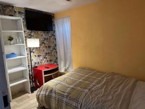 a bedroom with a bed and a tv on the wall at Casa Vázquez , "Como en casa" , hospédate con nosotros y recibirás una atención personalizada, servicio y confort nos distingue. in Pachuca de Soto