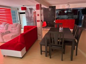 a living room with a red couch and a table and chairs at Casa Vázquez , "Como en casa" , hospédate con nosotros y recibirás una atención personalizada, servicio y confort nos distingue. in Pachuca de Soto