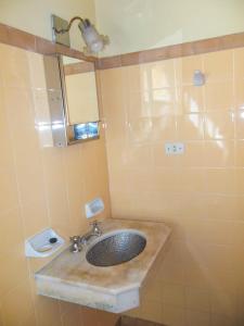 een badkamer met een wastafel en een spiegel bij Apart Cuidad de Córdoba in Termas de Río Hondo