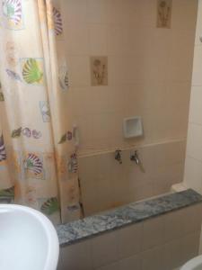 ein Bad mit einem Duschvorhang und einem Waschbecken in der Unterkunft Apart Cuidad de Córdoba in Termas de Río Hondo