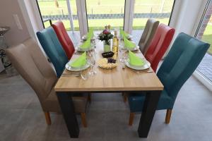 einem Esstisch mit Stühlen und einem Tisch mit Speisen in der Unterkunft Ferienhaus Marinapark 147 in Walchum