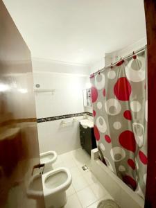 a bathroom with a toilet and a shower curtain at Posadas Aloja in Posadas