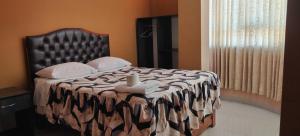 Una cama con una manta blanca y negra y una ventana en HOSTAL LLAUT * *, en Moquegua