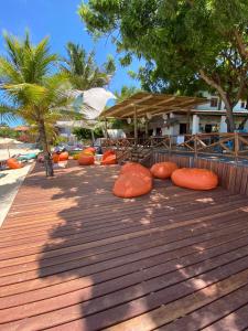 a wooden boardwalk with orange cushions on it at Pousada Casa Canto das Águas in Icaraí