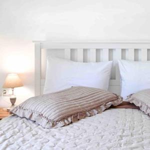 a white bed with a white headboard and pillows at Antonia in Plakias