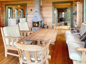 a living room with a wooden table and a fireplace at Holiday home YNGSJÖ II in Yngsjö