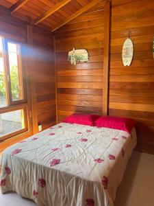 Residencial Coração do Mar في باليوسا: غرفة نوم بسرير ومخدات حمراء