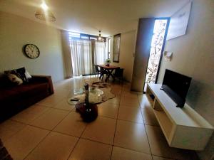 a living room with a couch and a tv at Wild Olive Inn 62 in Windhoek