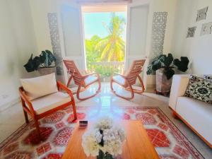 sala de estar con 2 sillas y mesa de centro en Hotel AT THE PARK en Cartagena de Indias
