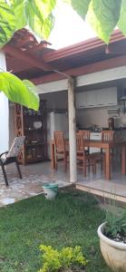eine Terrasse mit einem Tisch und Stühlen sowie eine Küche in der Unterkunft Casa da Tôta in São João Batista do Glória