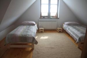 een slaapkamer op zolder met 2 bedden en een raam bij W Korcu Maku - dom wakacyjny in Rutka Tartak