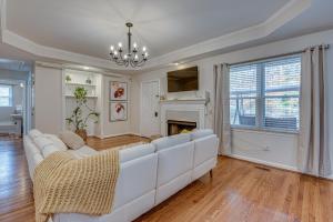 een woonkamer met een witte bank en een open haard bij Historic Covington Getaway with Fireplace and Yard! in Covington