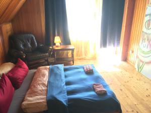 a room with a bed with a blue blanket and a chair at Sunnehof in Kleines Wiesental