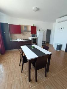 a kitchen with a table and chairs in a room at SeaWaves Apartments in Xgħajra