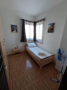 a small bedroom with a bed and a window at SeaWaves Apartments in Xgħajra