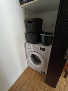 a washing machine with a bucket on top of it at SeaWaves Apartments in Xgħajra