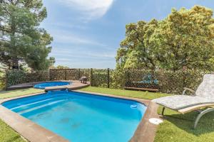 a swimming pool in a yard with a chair at La Cabaña in Valdemorillo