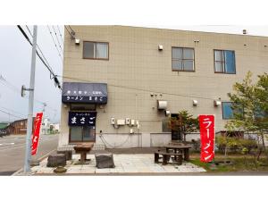 un edificio con bancos y mesas delante de él en GUEST HOUSE MASAGO - Vacation STAY 13806v, en Urakawa