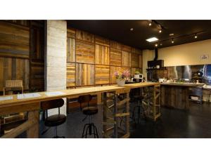 cocina grande con armarios de madera y taburetes de bar en GUEST HOUSE MASAGO - Vacation STAY 13806v en Urakawa