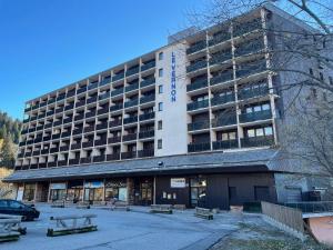 a large building with benches in front of it at Studio Cabine Chamrousse in Chamrousse