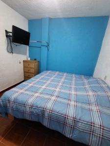 a blue bedroom with a bed and a television at Visita Pachuca junto a familia , 2 Recamaras 1- cama ks , Recamara 2 -1 Cama KS , baño privado , 1 Comedor (Refrigerador, desayunador, estufa ) in Pachuca de Soto