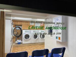 a laundry room with three washing machines and blue chairs at Studio Cabine Chamrousse in Chamrousse