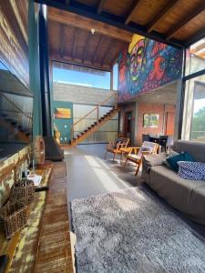 因比圖巴的住宿－Luxury Holiday Home In Ibiraquera-SC，客厅配有沙发和色彩缤纷的壁画