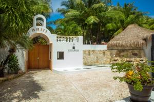 a white house with a thatch roof at Hidden Beach Resort Au Naturel Adults Only - All Inclusive in Akumal