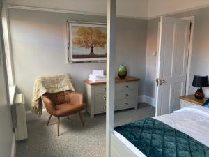 - une chambre avec un lit, une chaise et un bureau dans l'établissement Stylish Flat in Yeovil Somerset, à Yeovil