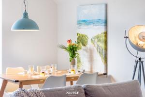 a dining room with a table and a painting of a beach at Ferienwohnung Nicks Seestern Olpenitz in Olpenitz